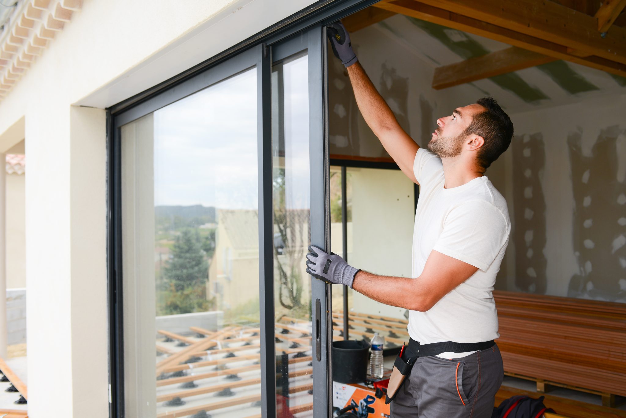 Construction worker installing a sliding window and door